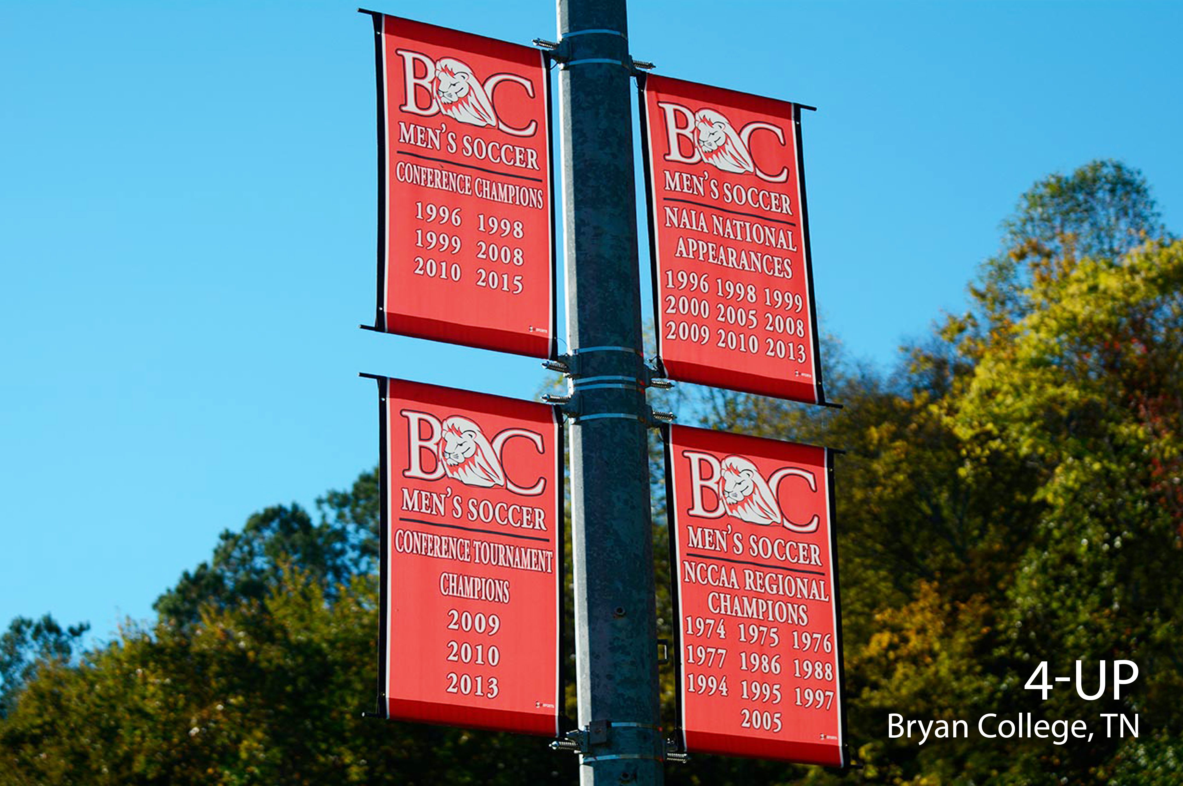 Multiple banner saver brackets on a street light pole with custom banners.