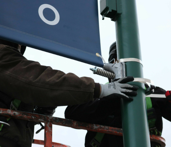 Two Men Work Together to Install Bannersaver Bracket