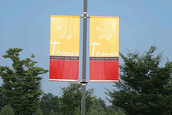 Light pole banners and bannersaver brackets