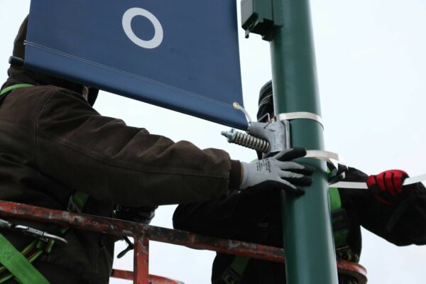 Two Men Work Together to Install Bannersaver Bracket