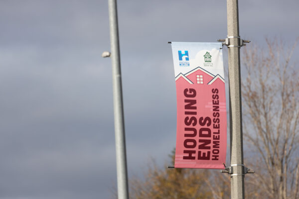 Banner that says Housing Ends Homelessness and bannersaver brackets