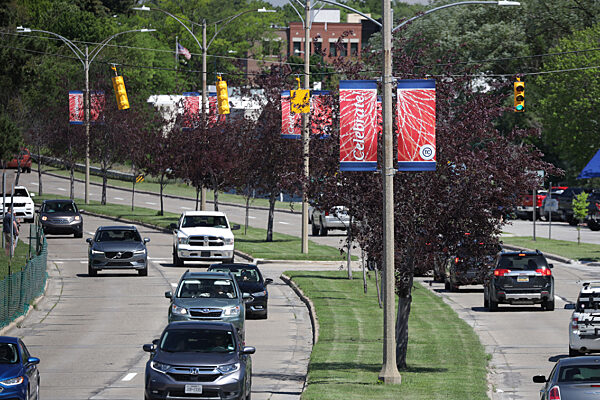 BannerSaver lamp post banner brackets with custom banners lining a busy street.